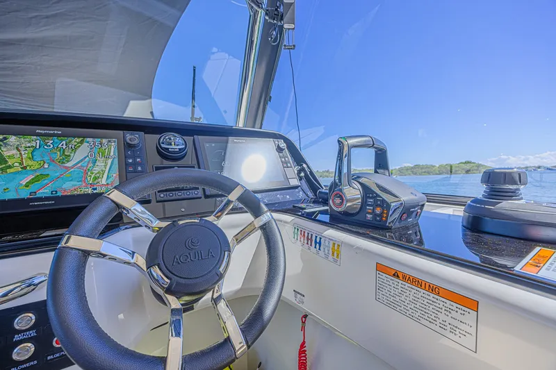 Slide: The Image of Helm of 2024 Aquila 36 Sport boat with navigation display and controls. - 36