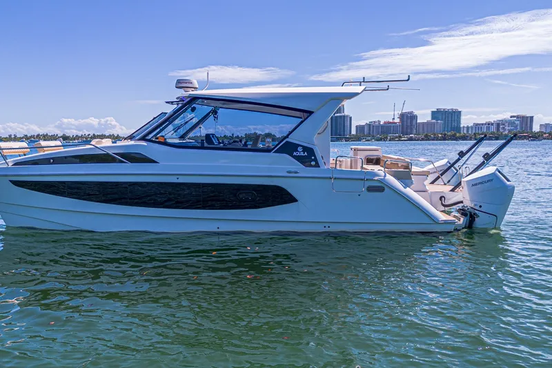 Slide: The Image of 2024 Aquila 36 Sport boat on water with city skyline in background. - 4