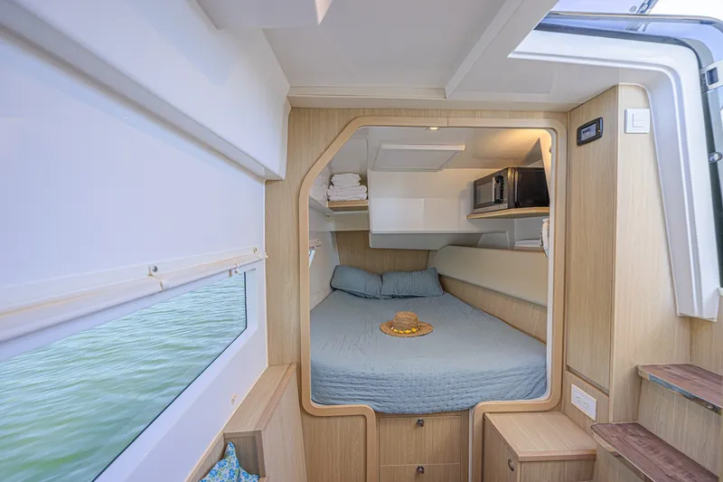 Slide: The Image of Interior cabin of 2024 Aquila 36 Sport boat with cozy bed and window view. - 39
