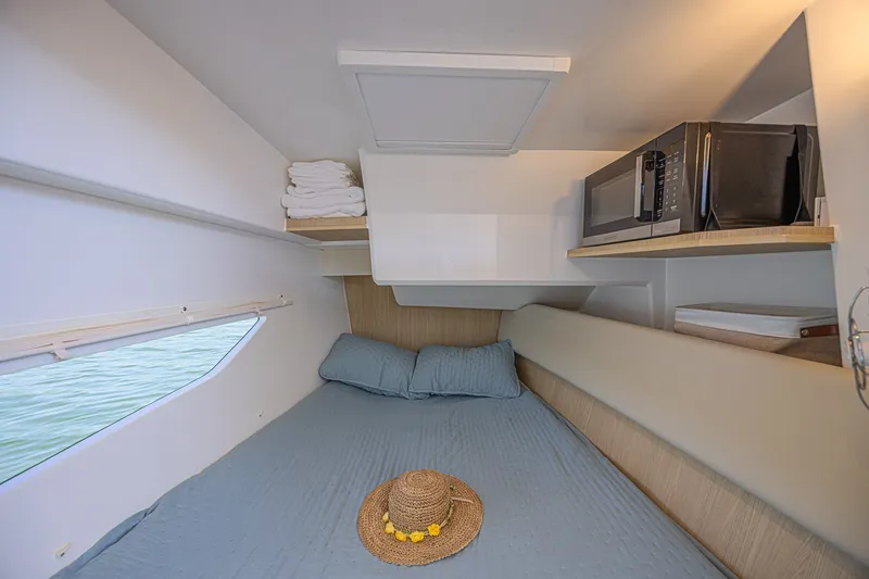 Slide: The Image of Cozy cabin interior of 2024 Aquila 36 Sport with bed, microwave, and window view. - 40
