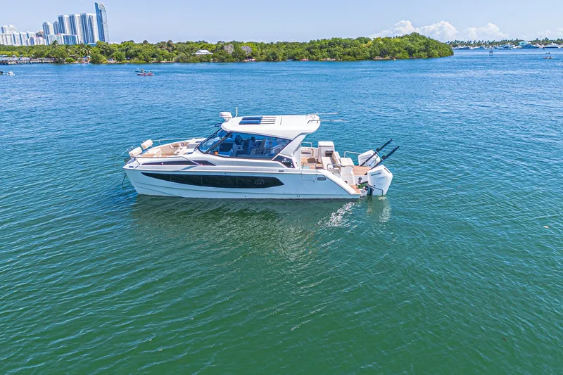 Slide: The Image of 2024 Aquila 36 Sport yacht cruising on a serene blue waterway. - 12
