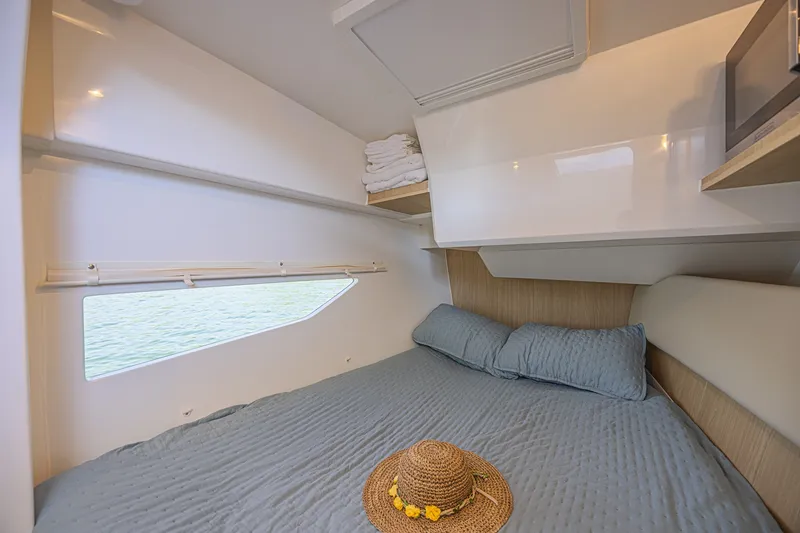 Slide: The Image of Cozy cabin interior of 2024 Aquila 36 Sport with bed, window, and straw hat. - 37