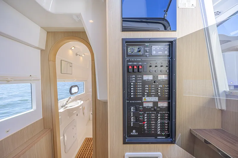 Slide: The Image of Interior of 2024 Aquila 36 Sport yacht featuring control panel and bathroom entrance. - 49
