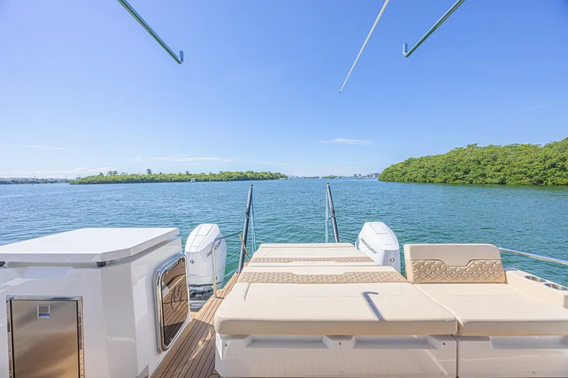 Slide: The Image of 2024 Aquila 36 Sport yacht with luxurious deck overlooking serene waters and lush greenery. - 16