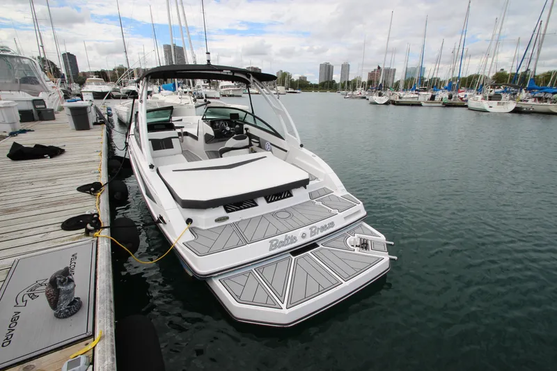 Slide: The Image of 2025 Monterey M-22 boat docked at marina with city skyline in background. - 4