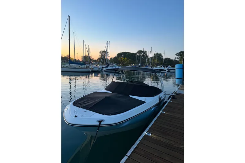 Slide: The Image of 2025 Monterey M-22 boat docked at marina during sunset, surrounded by sailboats. - 1
