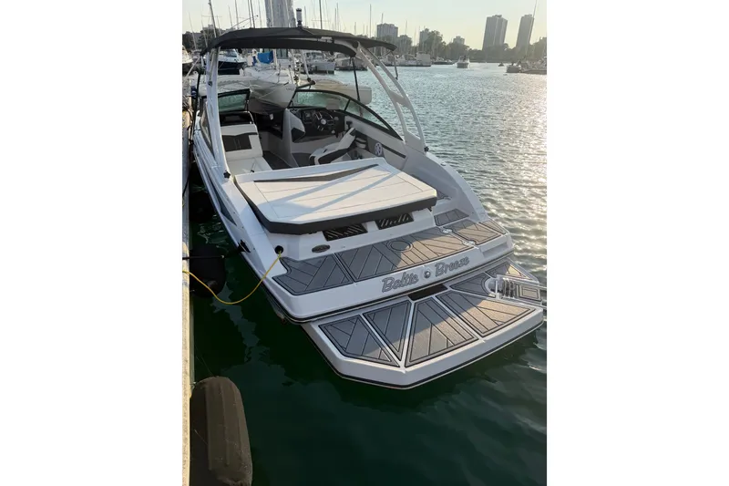 Slide: The Image of 2025 Monterey M-22 boat docked in a marina, with city skyline in the background. - 3