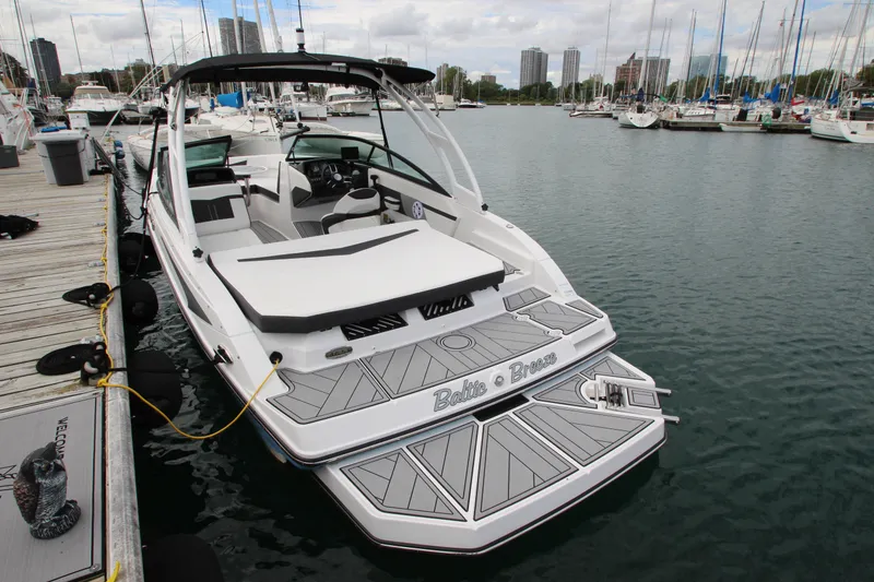 Slide: The Image of 2025 Monterey M-22 boat docked at marina with city skyline in background. - 5
