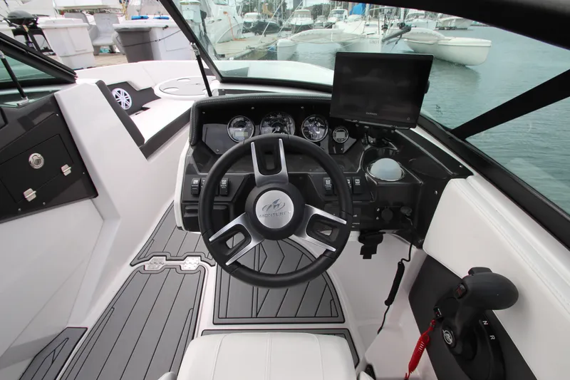 Slide: The Image of 2025 Monterey M-22 boat cockpit with steering wheel, gauges, and navigation screen. - 12