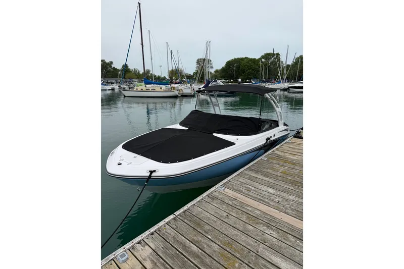 The Image of 2025 Monterey M-22 boat docked at a marina with sailboats in the background. - 0