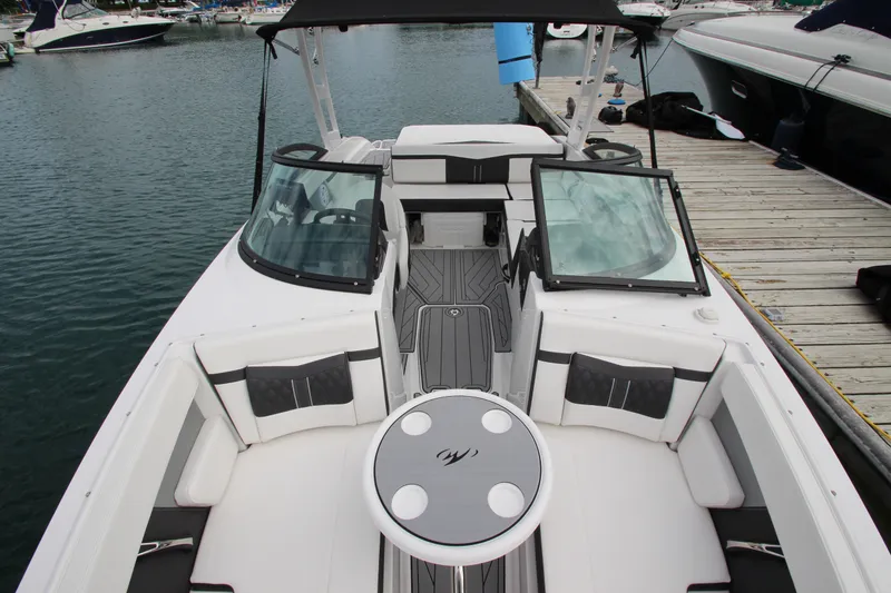 Slide: The Image of 2025 Monterey M-22 boat interior with seating and table, docked at marina. - 17