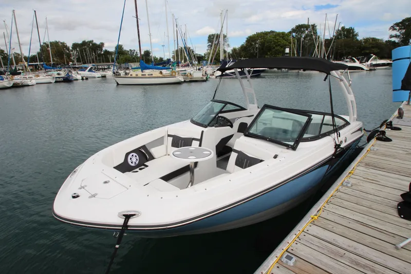 Slide: The Image of 2025 Monterey M-22 boat docked in a marina, featuring sleek design and spacious seating. - 2