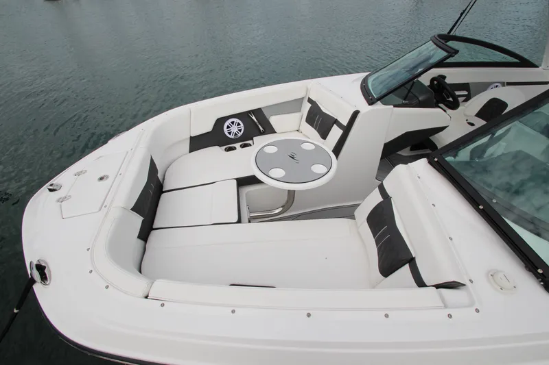 Slide: The Image of 2025 Monterey M-22 boat interior with white seating and round table on water. - 19