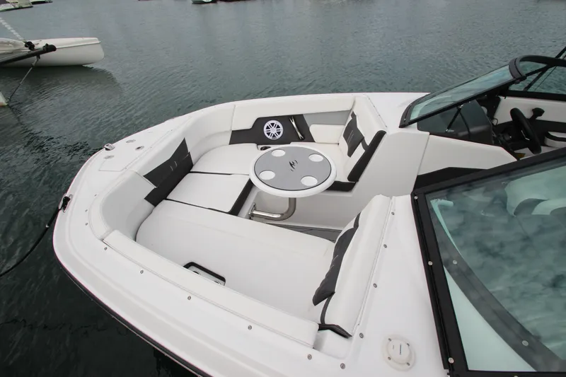 Slide: The Image of 2025 Monterey M-22 boat interior with seating and table on calm water. - 18