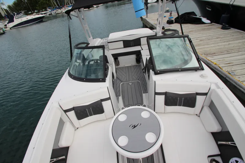 Slide: The Image of 2025 Monterey M-22 boat interior with seating and table, docked at marina. - 16