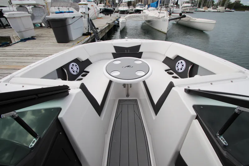 Slide: The Image of 2025 Monterey M-22 boat interior with seating and table, docked at marina. - 15