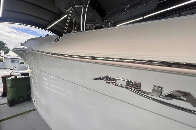 Slide: The Image of 2022 Aquasport 2300 Center Console boat in a garage, showcasing sleek design. - 4