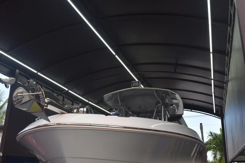 Slide: The Image of 2022 Aquasport 2300 Center Console boat under a covered dock. - 6