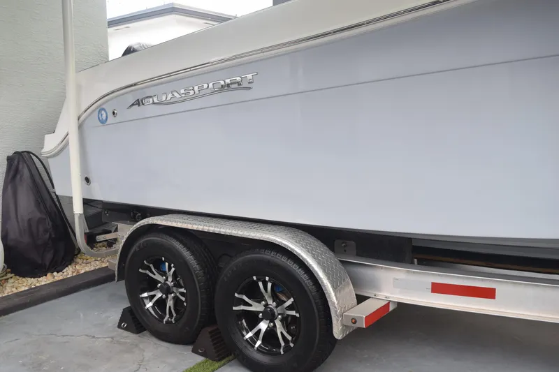 Slide: The Image of 2022 Aquasport 2300 Center Console boat on trailer, side view. - 15