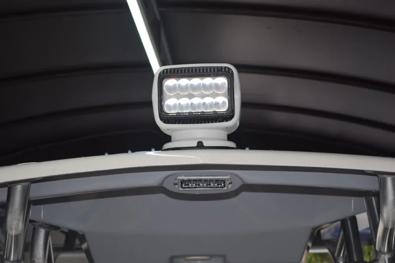 Slide: The Image of LED spotlight on 2022 Aquasport 2300 Center Console boat under canopy. - 56