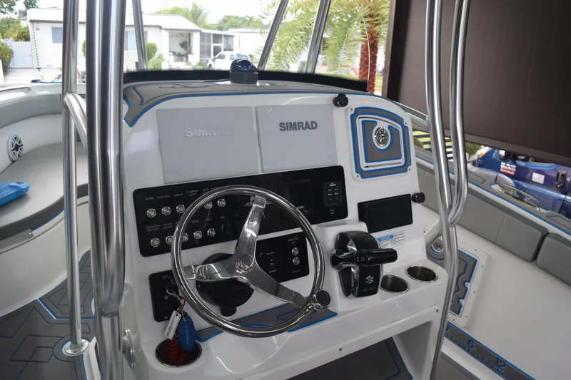 Slide: The Image of 2022 Aquasport 2300 Center Console boat dashboard with Simrad electronics and steering wheel. - 40