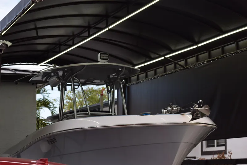 Slide: The Image of 2022 Aquasport 2300 Center Console boat under a covered dock. - 10