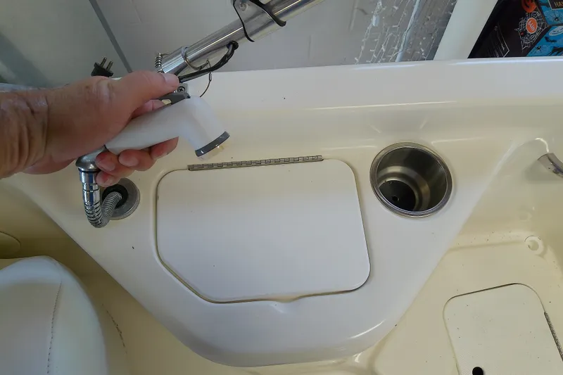 Slide: The Image of Hand holding a spray nozzle on a 2012 Hurricane SunDeck 217 OB boat. - 37
