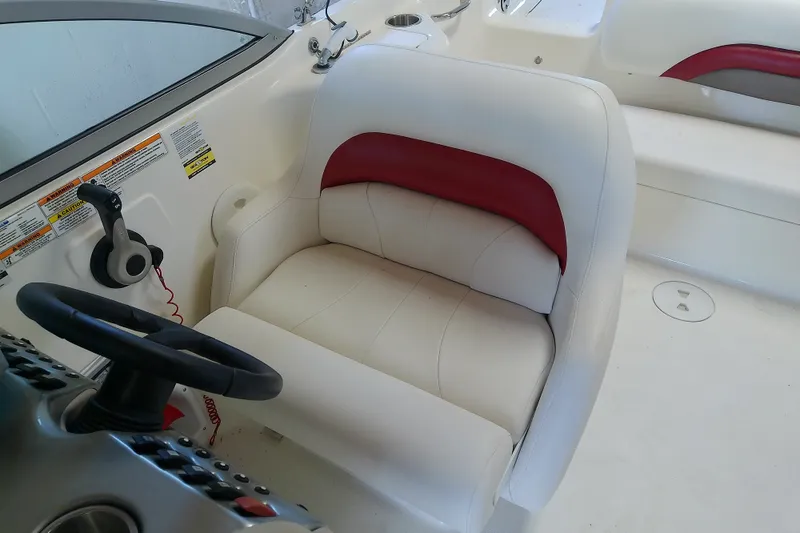 Slide: The Image of Captain's seat on 2012 Hurricane SunDeck 217 OB boat, featuring white and red upholstery. - 23