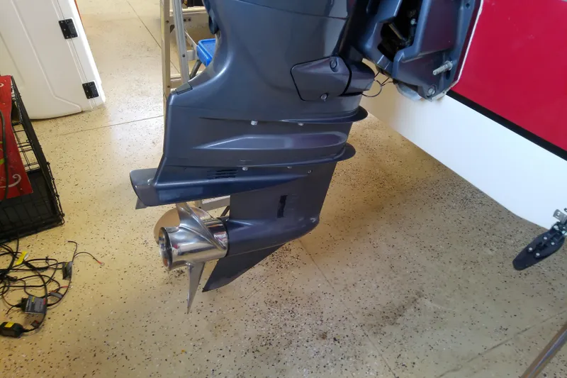 Slide: The Image of Outboard motor of 2012 Hurricane SunDeck 217 OB boat in a garage setting. - 18