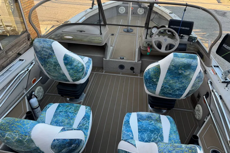 Slide: The Image of 2003 Crestliner Tournament 202 SC boat interior with blue patterned seats and steering console. - 26