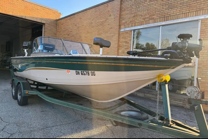 Slide: The Image of 2003 Crestliner Tournament 202 boat on trailer, parked outside a brick building. - 2