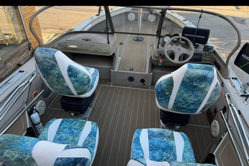 Slide: The Image of 2003 Crestliner Tournament 202 boat interior with blue patterned seats and navigation equipment. - 6
