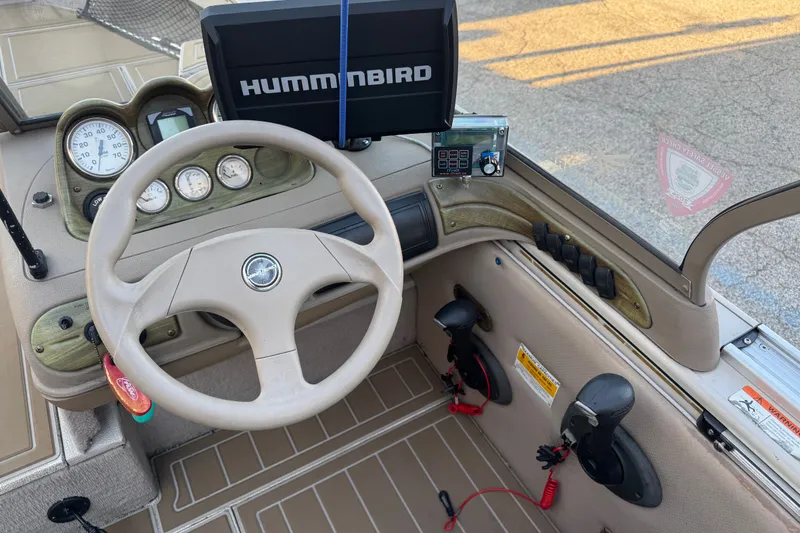 Slide: The Image of 2003 Crestliner Tournament 202 SC boat dashboard with steering wheel and Humminbird fish finder. - 16