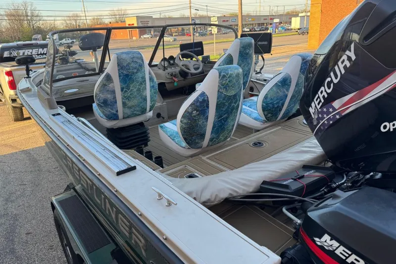 Slide: The Image of 2003 Crestliner Tournament 202 boat with Mercury engine, featuring blue patterned seats. - 5