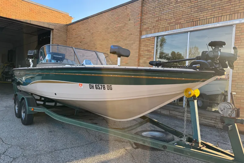 Slide: The Image of 2003 Crestliner Tournament 202 SC boat on trailer, parked outside a brick building. - 24