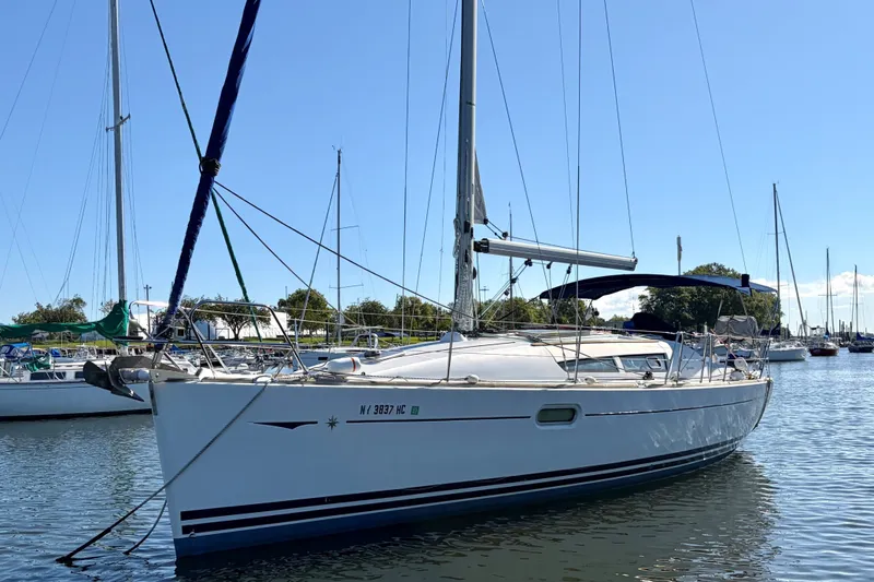 Slide: The Image of 2008 Jeanneau Sun Odyssey 36i sailboat docked in a marina under clear blue skies. - 24