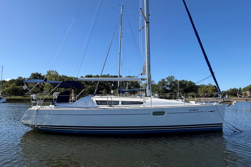 The Image of 2008 Jeanneau Sun Odyssey 36i sailboat on calm water under clear blue sky. - 0