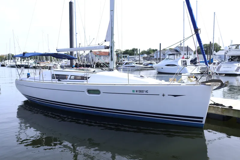 Slide: The Image of 2008 Jeanneau Sun Odyssey 36i sailboat docked at a marina, featuring sleek design and blue accents. - 25