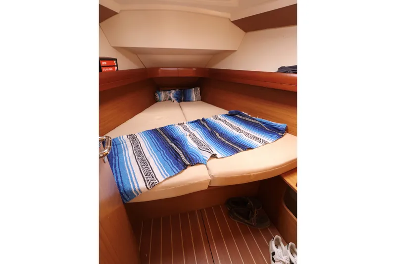 Slide: The Image of Cozy cabin interior of 2008 Jeanneau Sun Odyssey 36i with blue-striped blanket. - 17