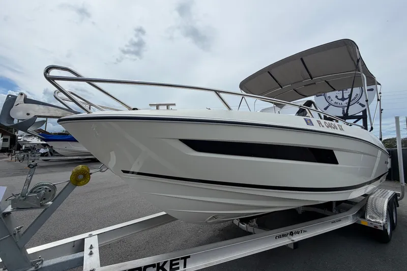 Slide: The Image of 2021 Parker Poland 690 Sport boat on trailer with canopy, parked outdoors. - 7