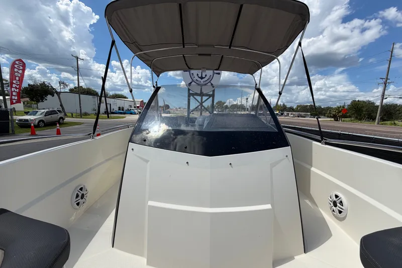 Slide: The Image of 2021 Parker Poland 690 Sport boat with canopy, parked outdoors under a cloudy sky. - 59