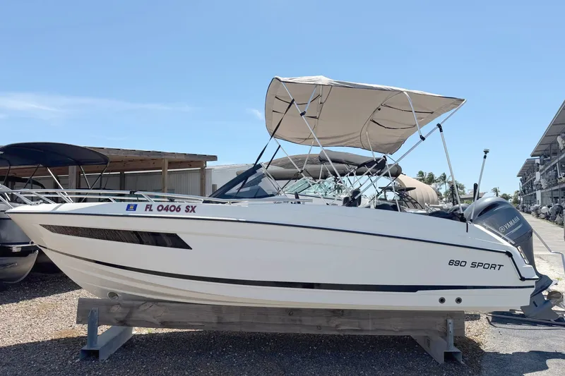The Image of A 2021 Parker Poland 690 Sport boat on a wooden stand, featuring a sunshade. - 0