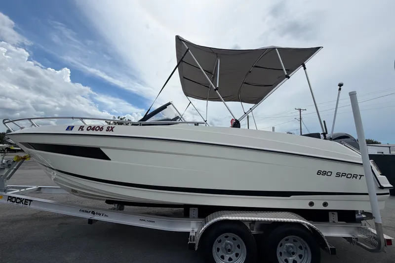 Slide: The Image of 2021 Parker Poland 690 Sport boat on trailer with canopy, parked outdoors. - 6