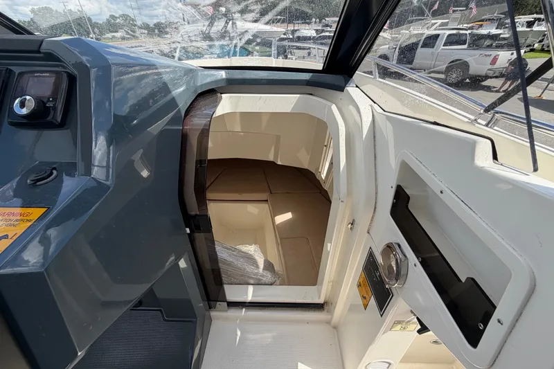 Slide: The Image of Interior cabin view of 2021 Parker Poland 690 Sport boat, showcasing seating and dashboard. - 33