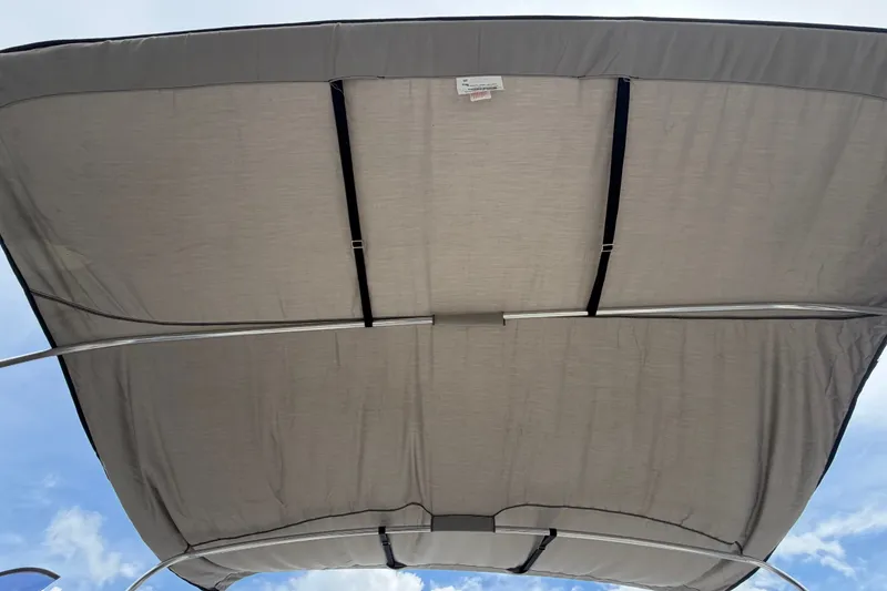 Slide: The Image of Bimini top of 2021 Parker Poland 690 Sport boat against blue sky. - 13