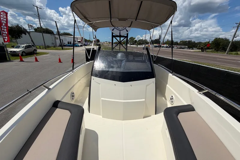 Slide: The Image of 2021 Parker Poland 690 Sport boat with canopy and seating, parked near a road. - 58