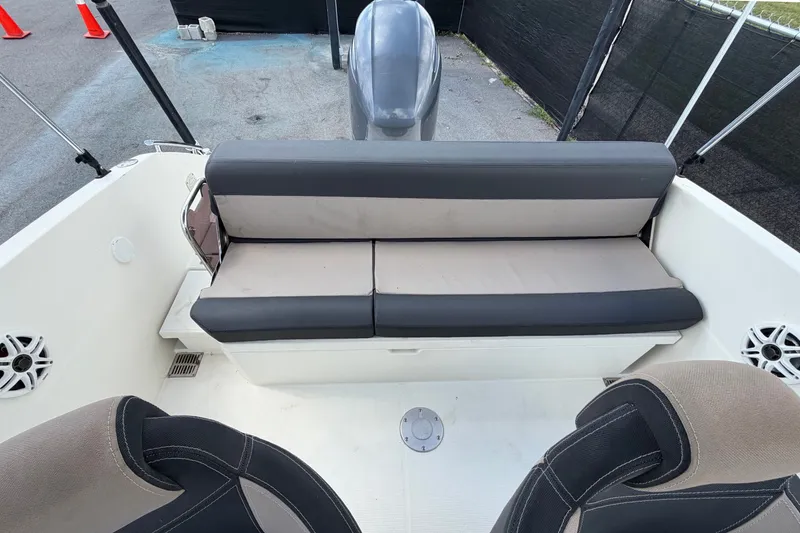 Slide: The Image of 2021 Parker Poland 690 Sport boat interior with cushioned seating and motor view. - 66
