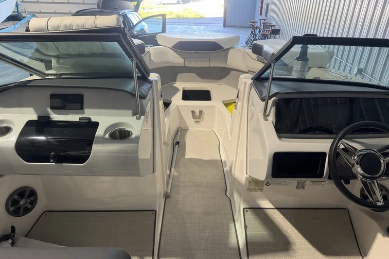 Slide: The Image of 2021 Regal LS2 boat interior with dual consoles and seating, in a well-lit storage area. - 16