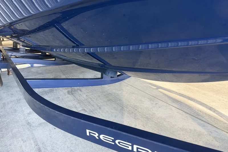 Slide: The Image of 2021 Regal LS2 boat hull on trailer, showcasing sleek blue design. - 4