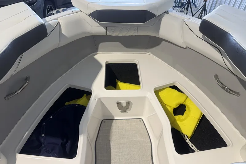 Slide: The Image of Bow seating area of a 2021 Regal LS2 boat with storage compartments and life jackets. - 20